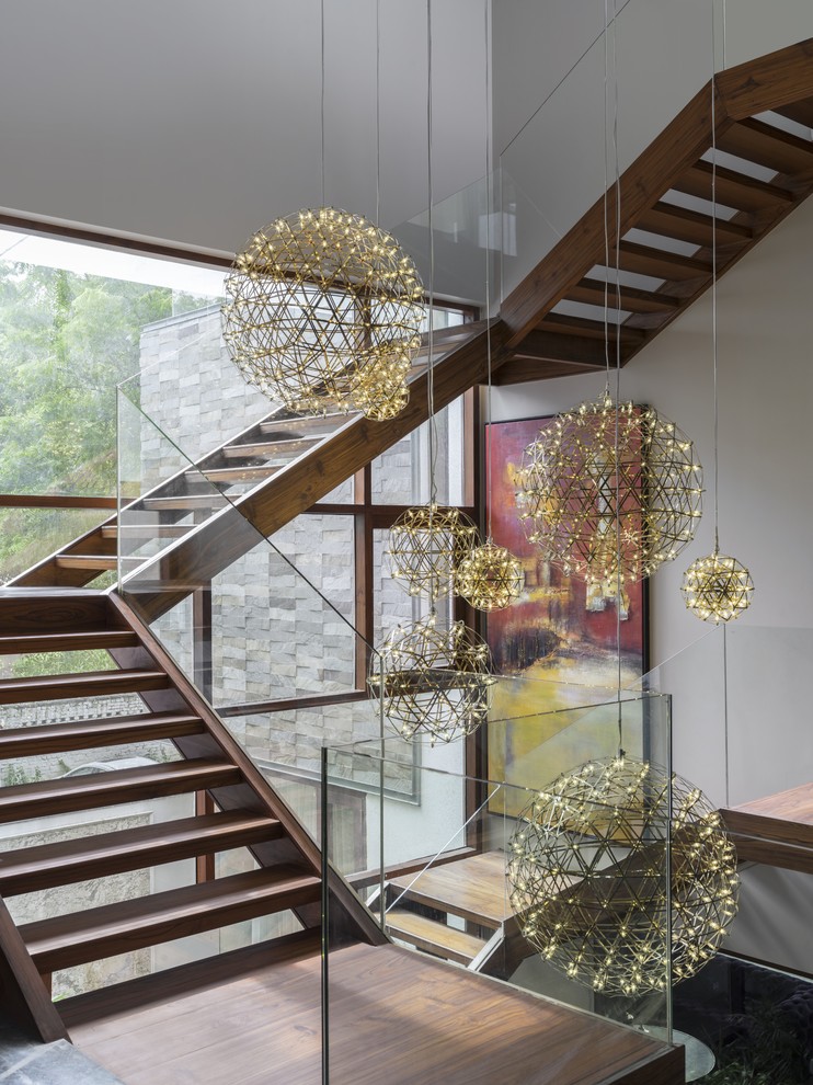 Aménagement d'un escalier sans contremarche contemporain en U avec des marches en bois, un garde-corps en verre et palier.