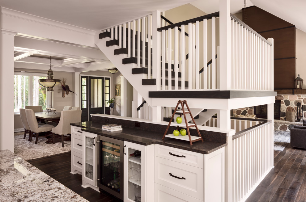 Стильный дизайн: изогнутая лестница среднего размера в стиле неоклассика (современная классика) с деревянными ступенями и деревянными перилами - последний тренд