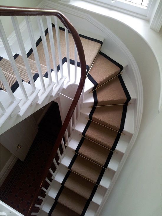 На фото: большая изогнутая лестница в классическом стиле с крашенными деревянными ступенями и крашенными деревянными подступенками