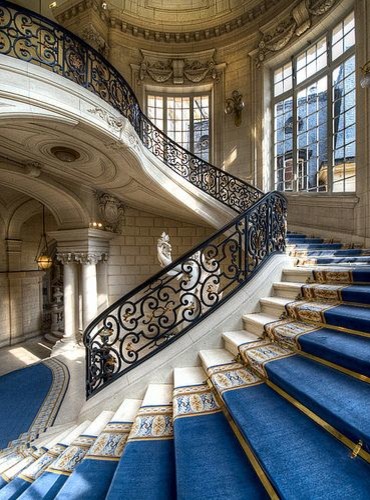 На фото: огромная изогнутая лестница в классическом стиле с ступенями из плитки и подступенками из плитки с