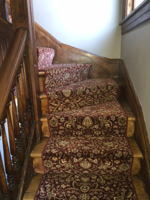 На фото: изогнутая лестница среднего размера в классическом стиле с ступенями с ковровым покрытием и ковровыми подступенками