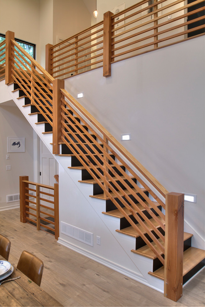 Cette image montre un grand escalier droit minimaliste avec des marches en bois, des contremarches en bois et un garde-corps en bois.