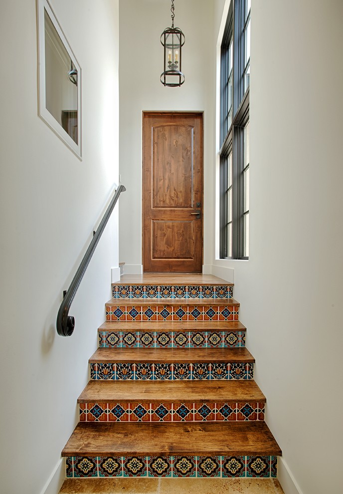 Diseño de escalera recta mediterránea con escalones de madera, contrahuellas con baldosas y/o azulejos y barandilla de metal