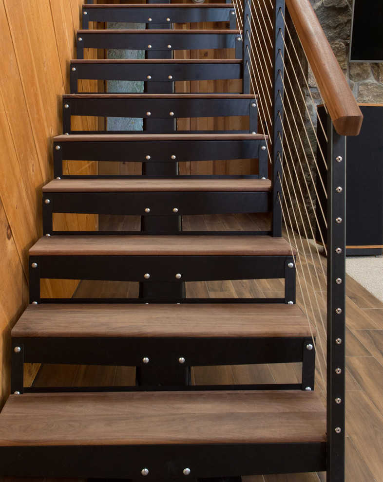 Diseño de escalera suspendida rural de tamaño medio con escalones de madera, contrahuellas de metal y barandilla de madera