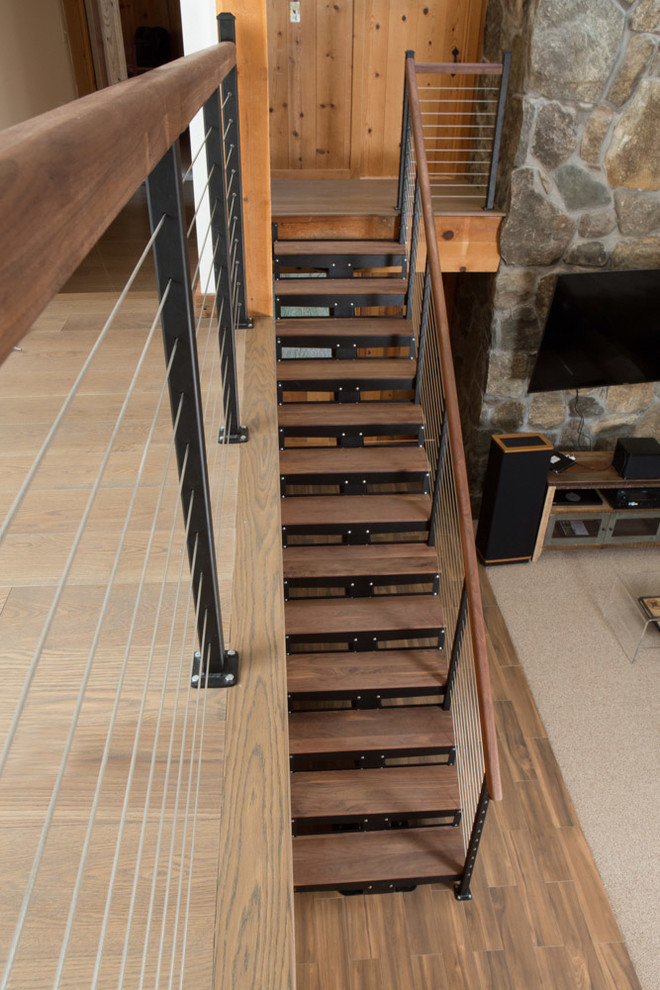Exemple d'un escalier flottant montagne de taille moyenne avec des marches en bois, des contremarches en métal et un garde-corps en bois.