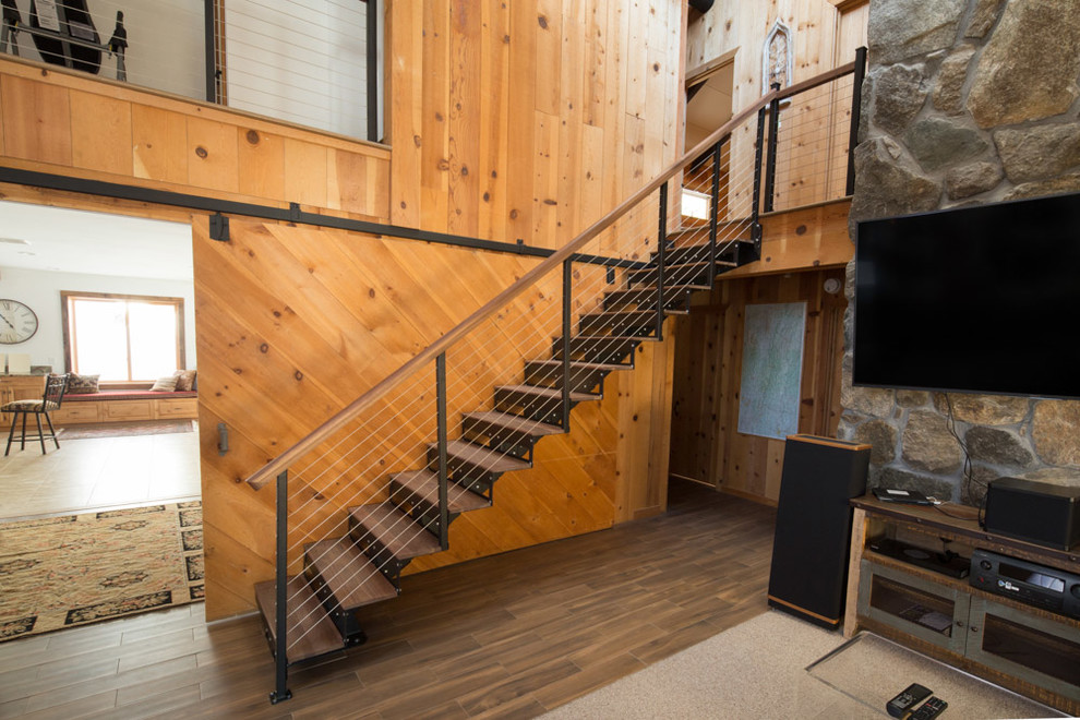 Réalisation d'un escalier flottant chalet de taille moyenne avec des marches en bois, des contremarches en métal et un garde-corps en bois.