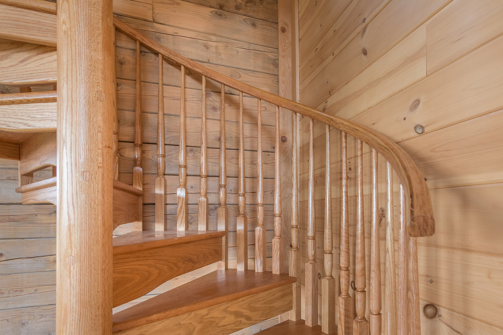 Idée de décoration pour un escalier hélicoïdal chalet avec des marches en bois et des contremarches en bois.