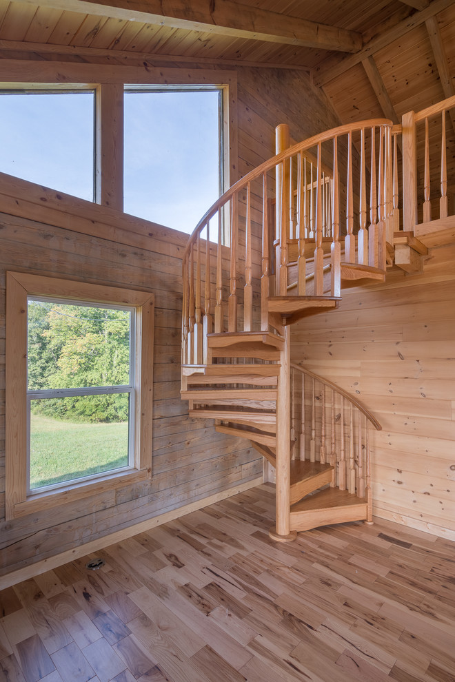 На фото: винтовая деревянная лестница в стиле рустика с деревянными ступенями с