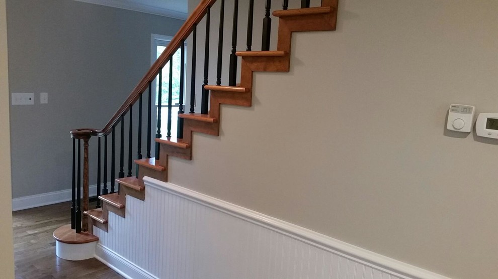 Ejemplo de escalera recta rústica de tamaño medio con escalones de madera, contrahuellas de madera y barandilla de madera