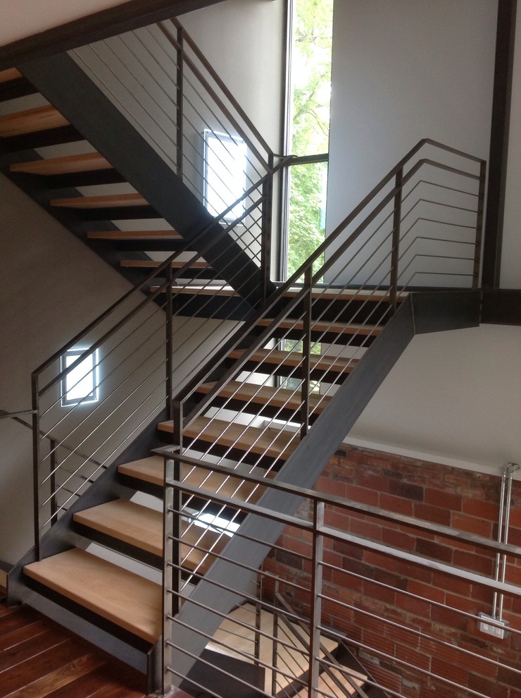 Идея дизайна: большая п-образная лестница в стиле лофт с деревянными ступенями и металлическими перилами без подступенок