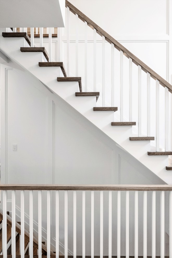 На фото: прямая лестница среднего размера в классическом стиле с деревянными ступенями, крашенными деревянными подступенками и деревянными перилами с