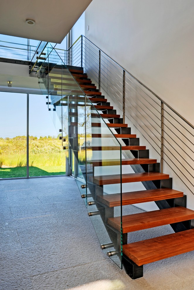 Стильный дизайн: большая прямая лестница в стиле модернизм с деревянными ступенями без подступенок - последний тренд