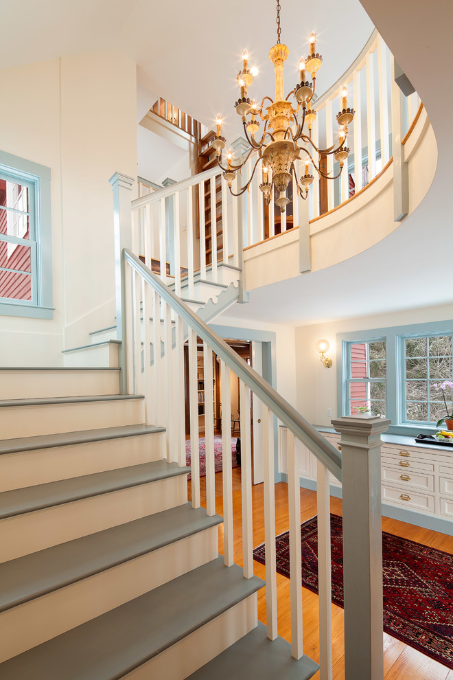 Diseño de escalera en L de estilo de casa de campo grande con escalones de madera pintada y contrahuellas de madera pintada