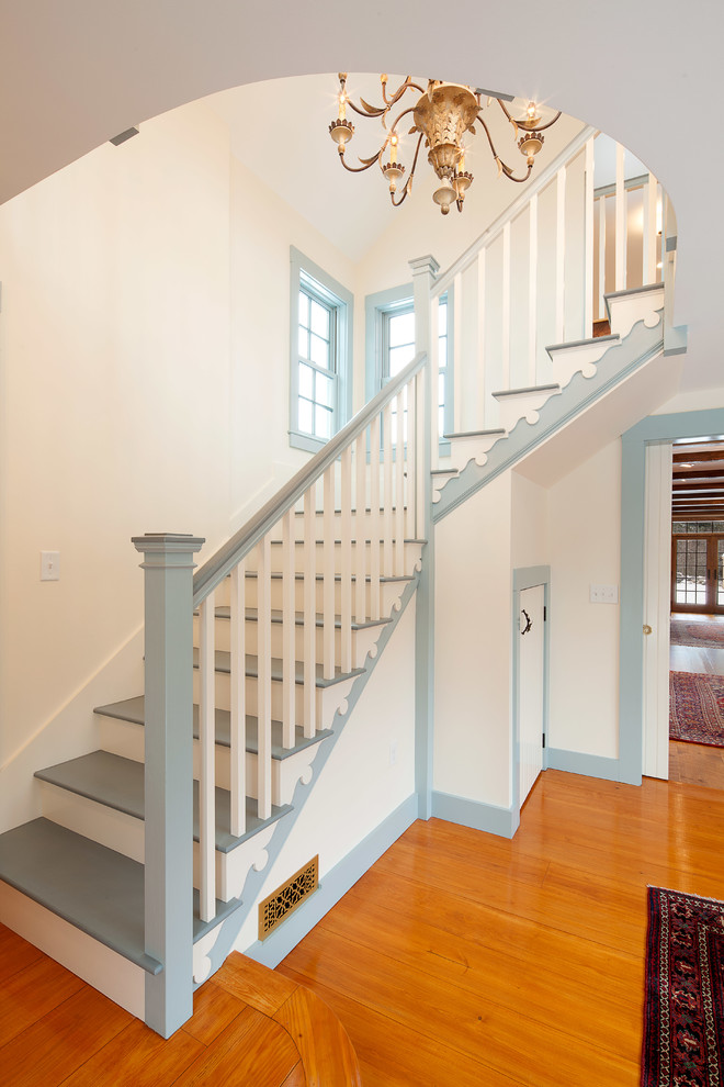 This is an example of a large country painted wood l-shaped staircase in Boston with painted wood risers.