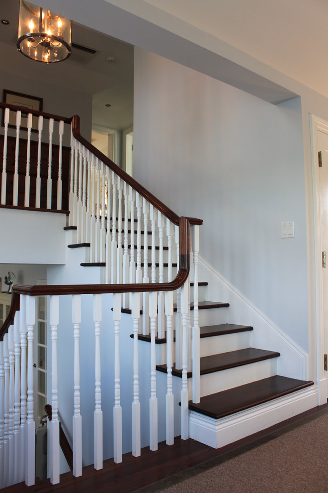 Ejemplo de escalera en U clásica grande con escalones de madera y contrahuellas de madera pintada