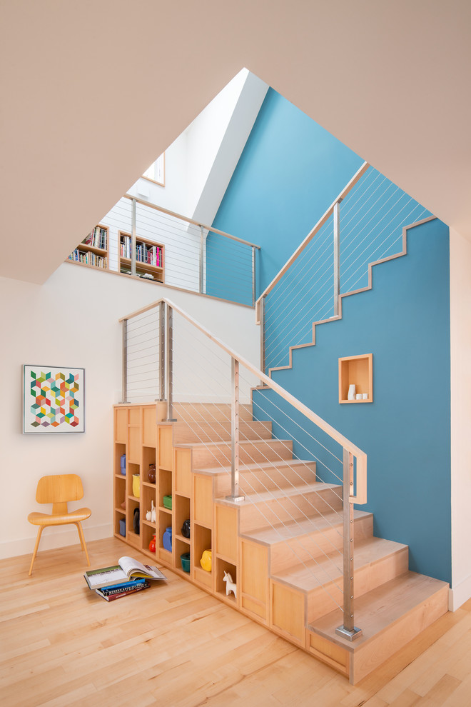 Imagen de escalera en U contemporánea con escalones de madera, contrahuellas de madera y barandilla de cable