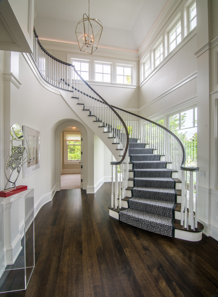 Example of a transitional wooden curved wood railing staircase design in Chicago with wooden risers