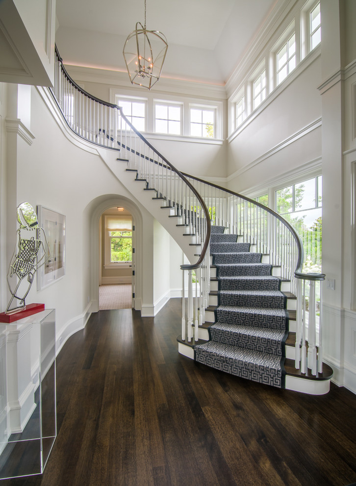 Foto de escalera curva, tradicional renovada, con escalones de madera, contrahuellas de madera y barandilla de madera
