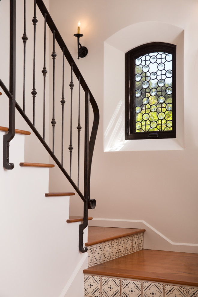 Стильный дизайн: лестница в средиземноморском стиле с подступенками из плитки - последний тренд