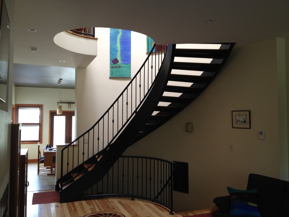 На фото: винтовая лестница среднего размера в современном стиле с деревянными ступенями
