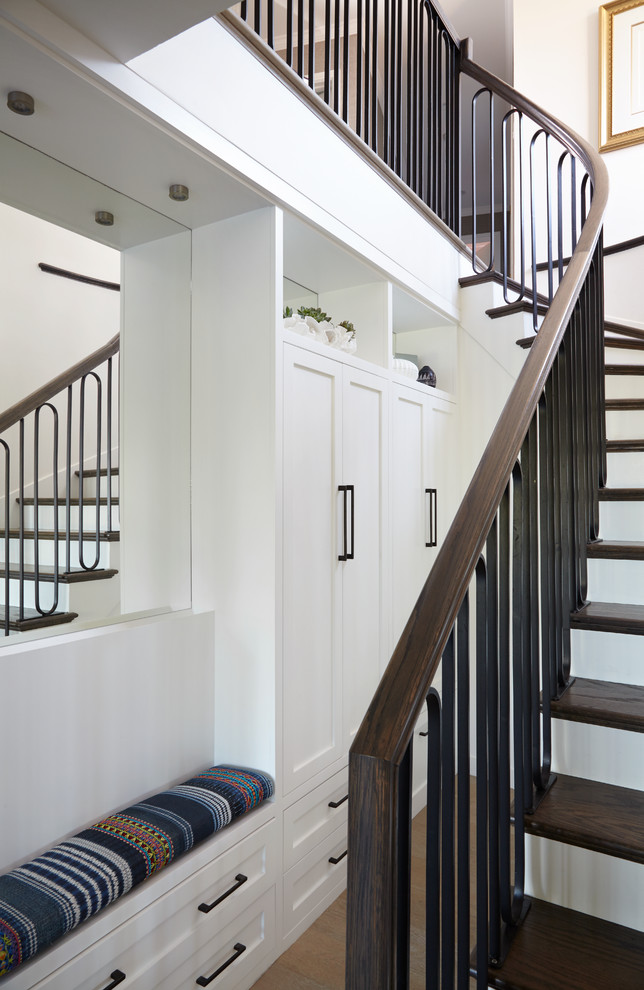 Стильный дизайн: изогнутая лестница среднего размера в стиле неоклассика (современная классика) с деревянными ступенями и крашенными деревянными подступенками - последний тренд