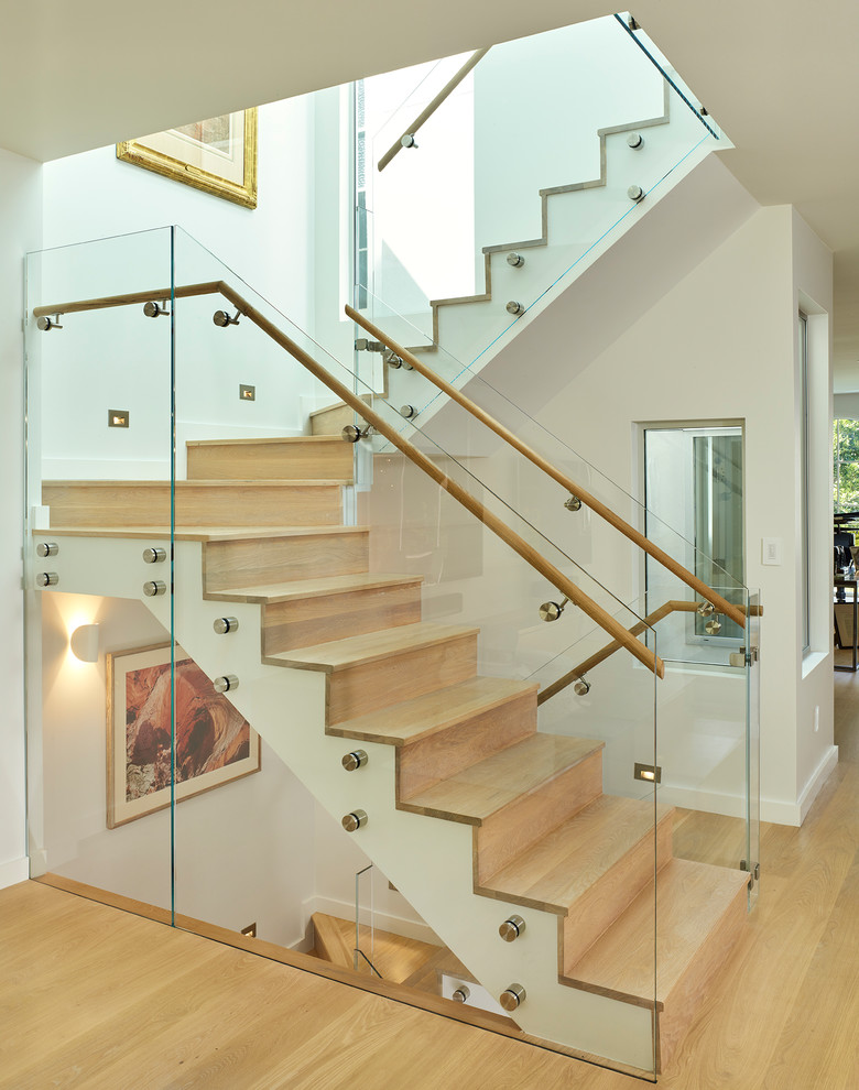 На фото: п-образная деревянная лестница в современном стиле с деревянными ступенями и перилами из смешанных материалов с