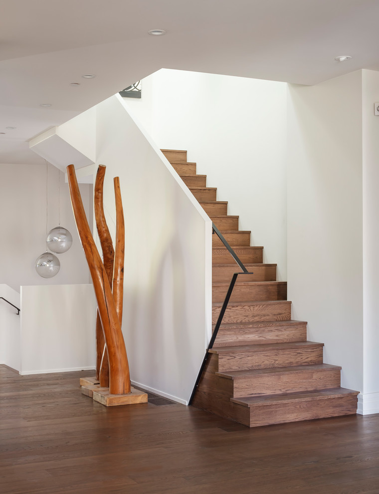 Inspiration pour un escalier design en L de taille moyenne avec des marches en bois, des contremarches en bois, un garde-corps en métal et palier.