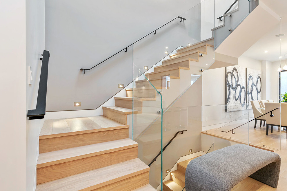 Aménagement d'un escalier contemporain en U avec des marches en bois, des contremarches en bois, palier et éclairage.