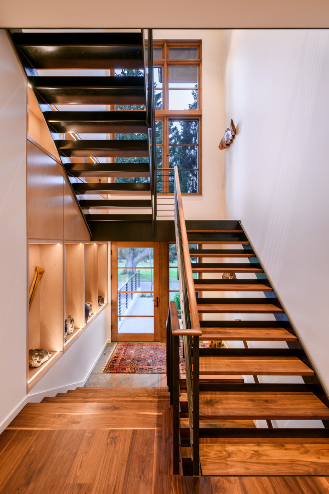 Exemple d'un grand escalier sans contremarche tendance en U avec des marches en bois, un garde-corps en métal et palier.
