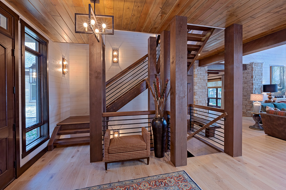 На фото: п-образная лестница в стиле рустика с деревянными ступенями и перилами из смешанных материалов без подступенок