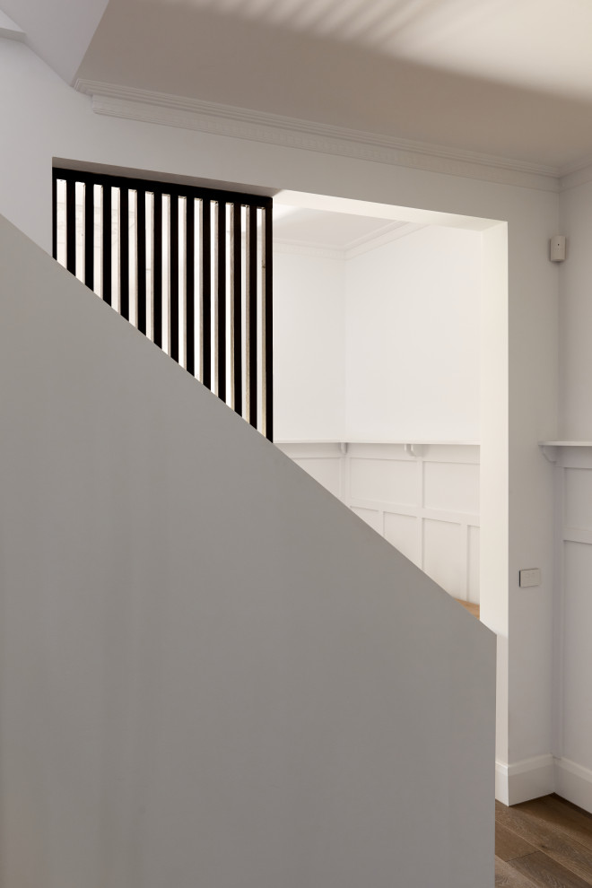 Стильный дизайн: угловая деревянная лестница среднего размера в стиле модернизм с деревянными ступенями и металлическими перилами - последний тренд