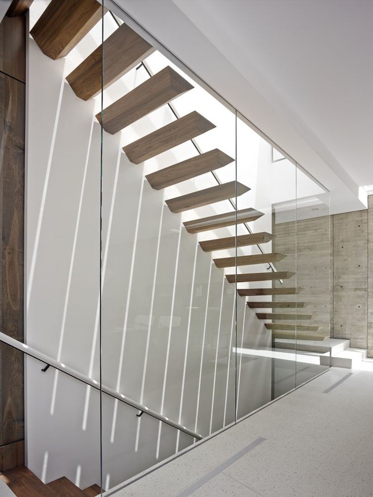 Ejemplo de escalera suspendida minimalista grande con escalones de madera y contrahuellas de hormigón