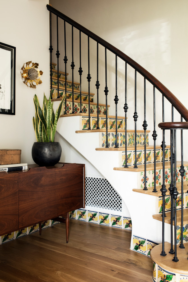 Источник вдохновения для домашнего уюта: изогнутая лестница в средиземноморском стиле с деревянными ступенями, подступенками из плитки и перилами из смешанных материалов