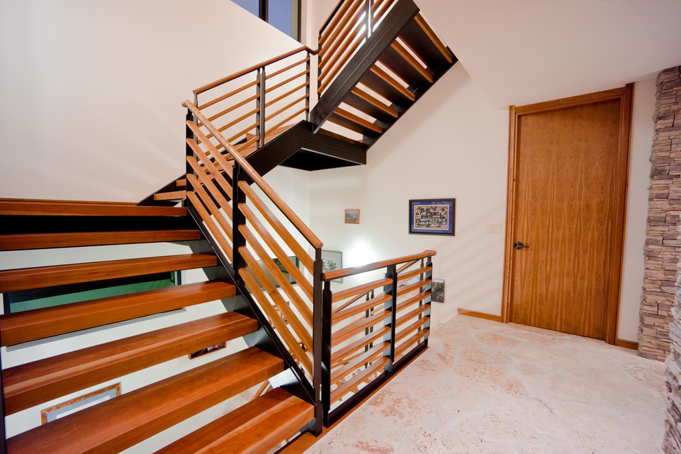 Пример оригинального дизайна: большая п-образная лестница в стиле ретро с деревянными ступенями и перилами из смешанных материалов без подступенок