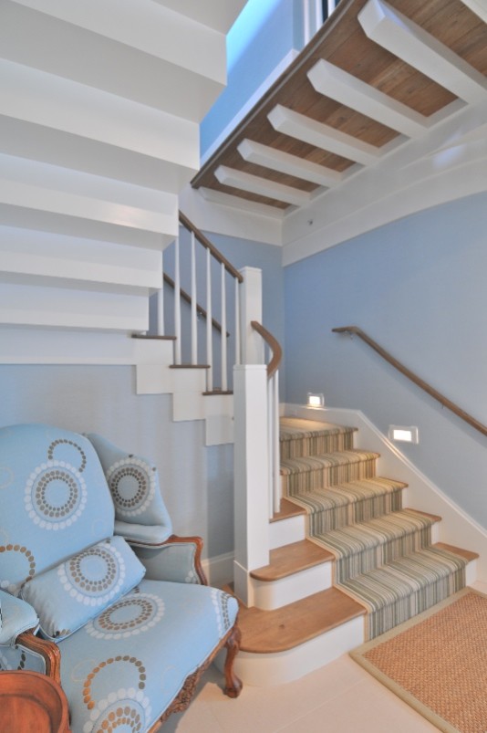 Diseño de escalera en U marinera grande con escalones de madera, contrahuellas de madera pintada y barandilla de madera