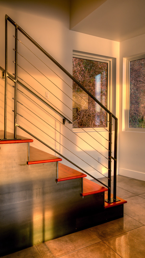 Exemple d'un escalier droit moderne de taille moyenne avec des marches en bois, des contremarches en métal et un garde-corps en métal.