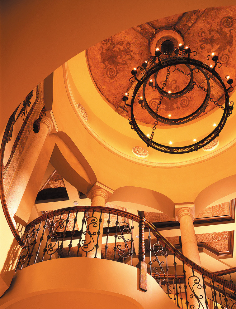 На фото: огромная изогнутая деревянная лестница в средиземноморском стиле с деревянными ступенями с