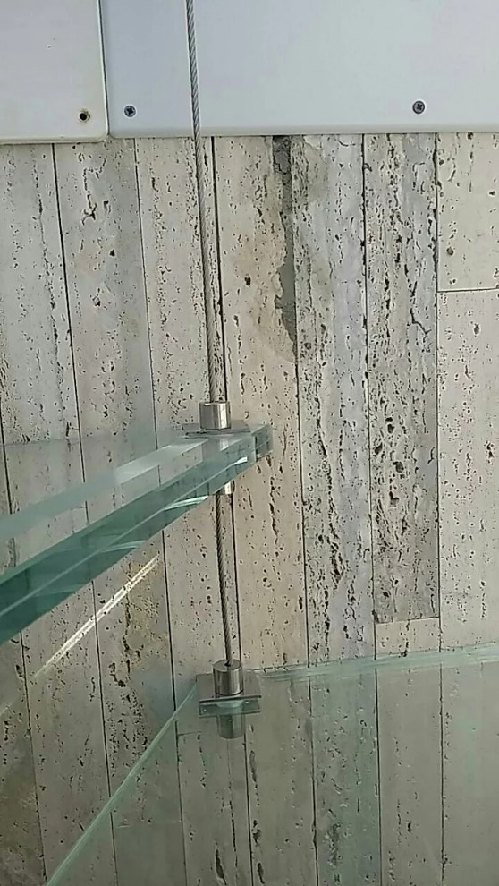 Cette photo montre un petit escalier sans contremarche hélicoïdal méditerranéen avec des marches en verre et un garde-corps en métal.