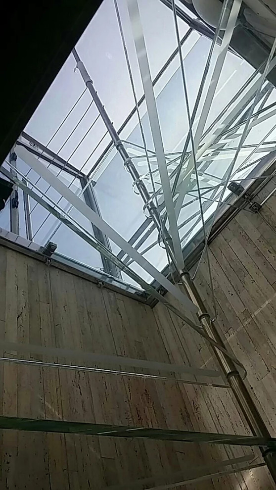 Aménagement d'un petit escalier sans contremarche hélicoïdal méditerranéen avec des marches en verre et un garde-corps en métal.