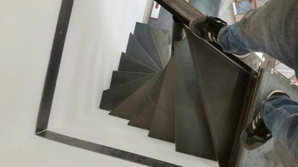 Imagen de escalera de caracol industrial pequeña sin contrahuella con escalones de metal y barandilla de metal