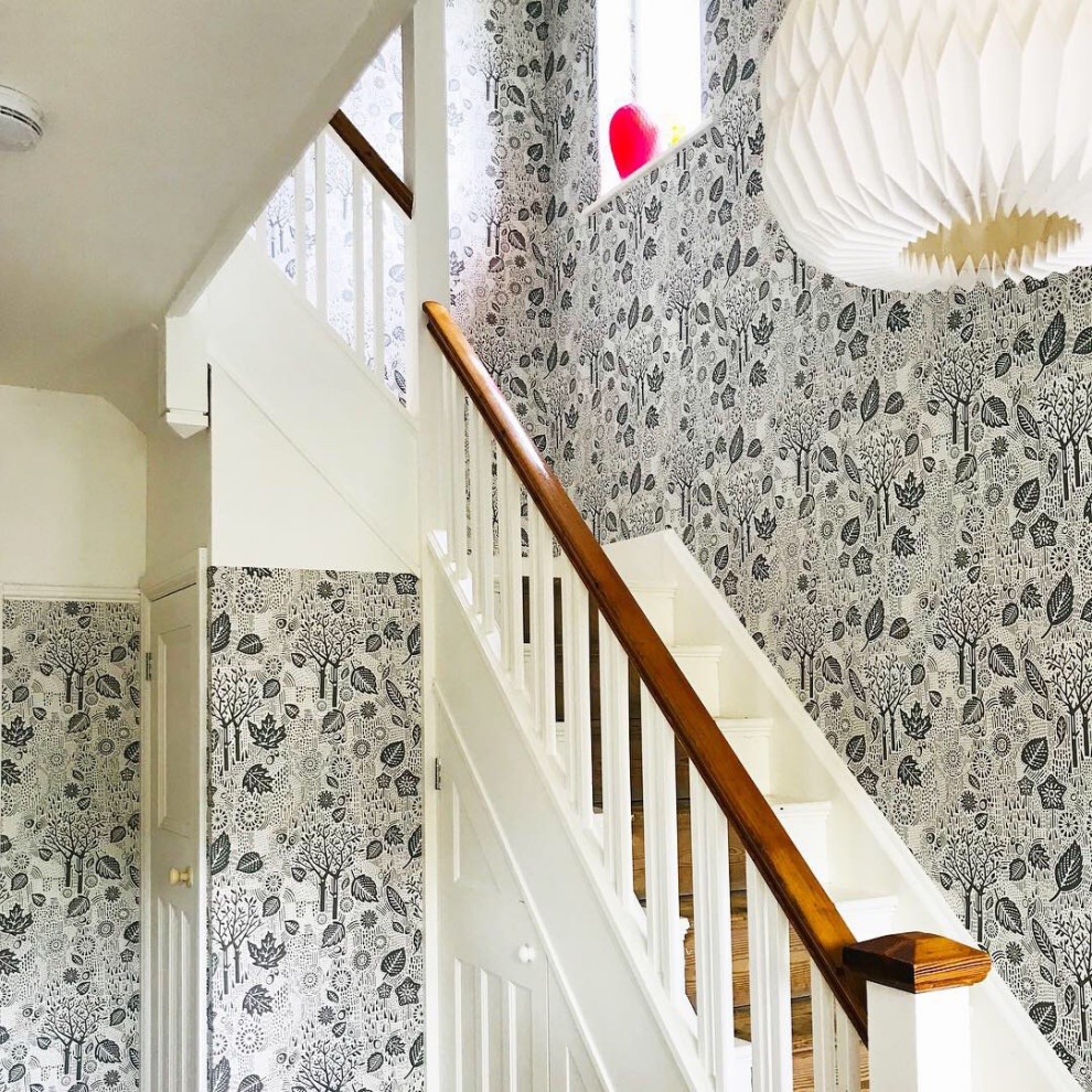 Mid-sized danish wooden l-shaped wood railing and wallpaper staircase photo in Cambridgeshire with wooden risers
