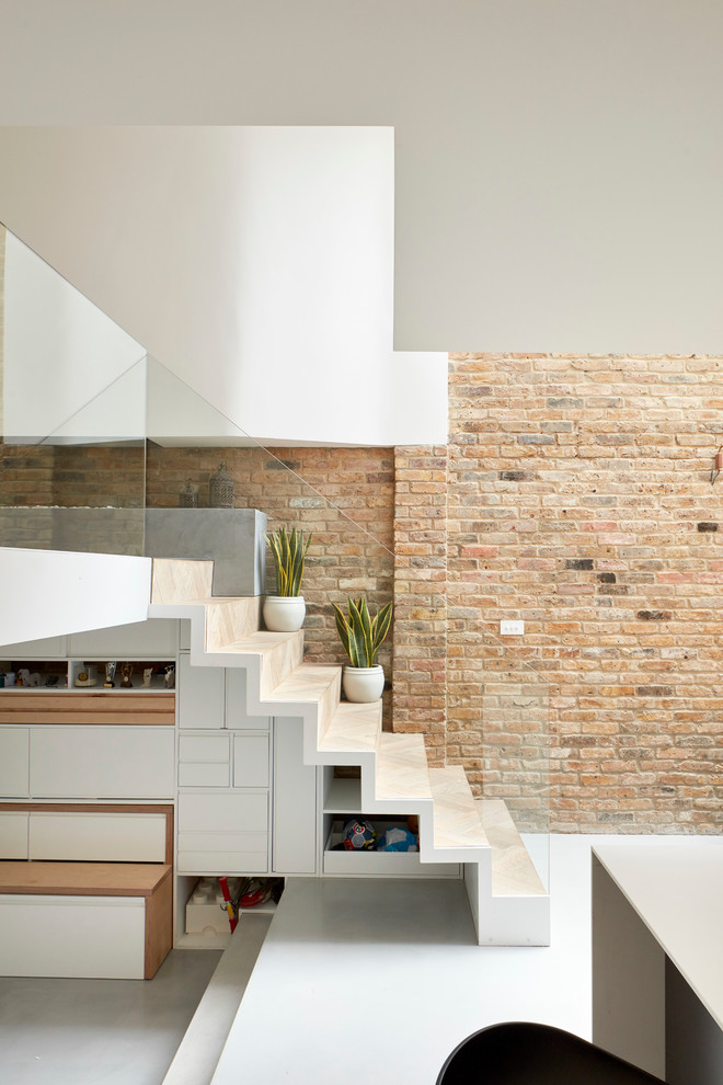 Contemporary wood staircase in London with wood risers and under stair storage.