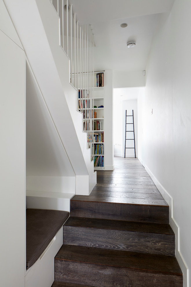 Aménagement d'un grand escalier droit contemporain avec des marches en bois, des contremarches en bois et éclairage.