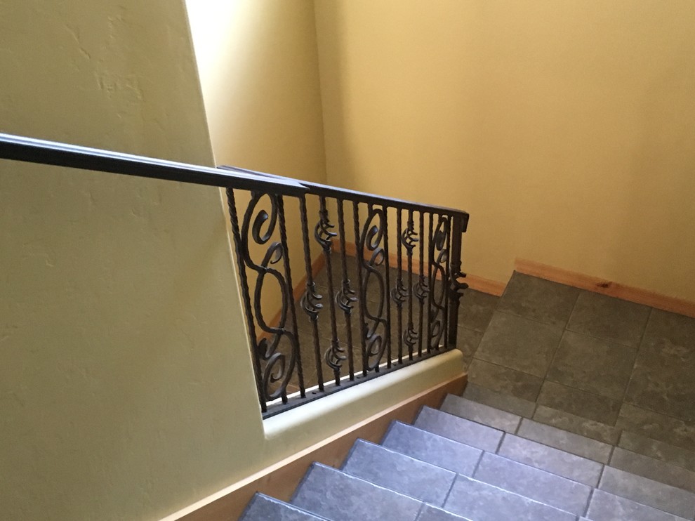 Inspiration pour un escalier carrelé minimaliste en U de taille moyenne avec des contremarches carrelées et un garde-corps en métal.