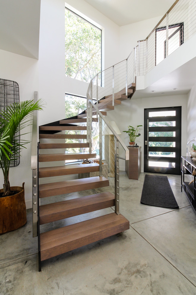 Пример оригинального дизайна: лестница на больцах, среднего размера в стиле модернизм с деревянными ступенями и металлическими перилами