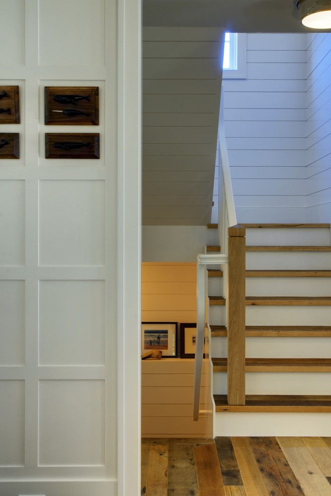 На фото: п-образная лестница в стиле неоклассика (современная классика) с деревянными ступенями с