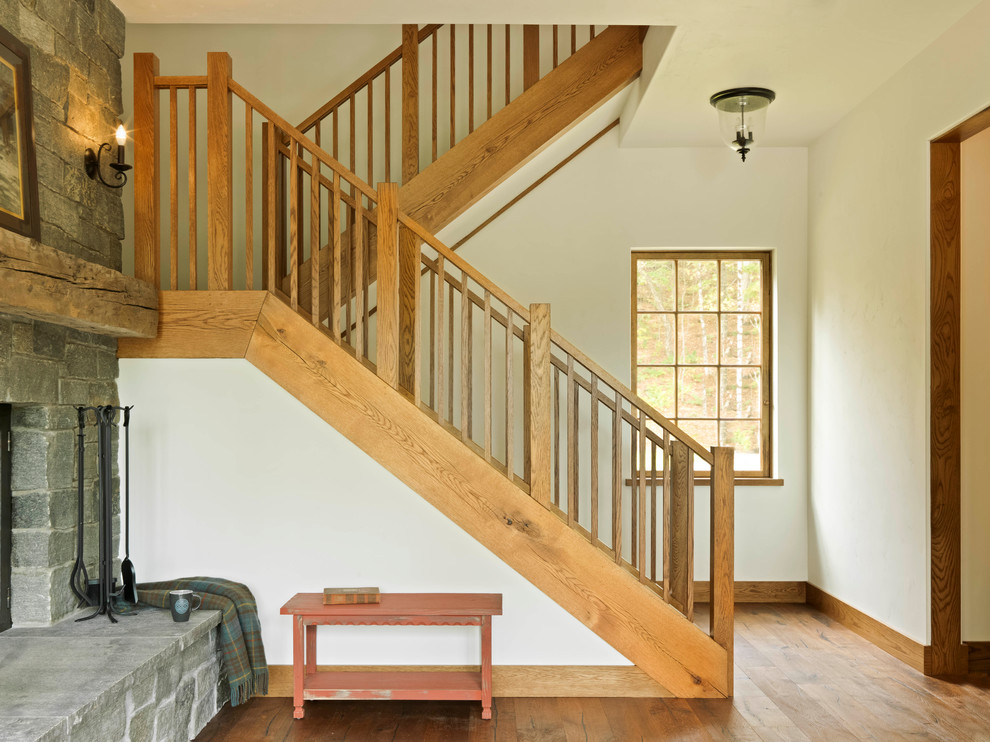 Ejemplo de escalera en U de estilo de casa de campo de tamaño medio con contrahuellas de madera y barandilla de madera