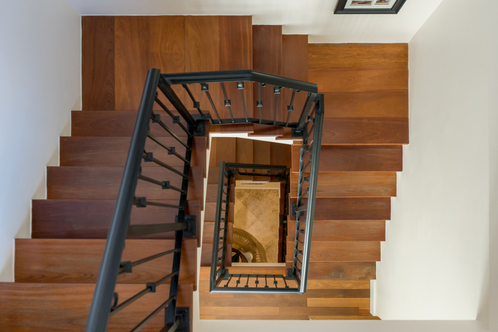 Modelo de escalera de estilo de casa de campo grande con escalones de madera, contrahuellas de madera pintada y barandilla de metal