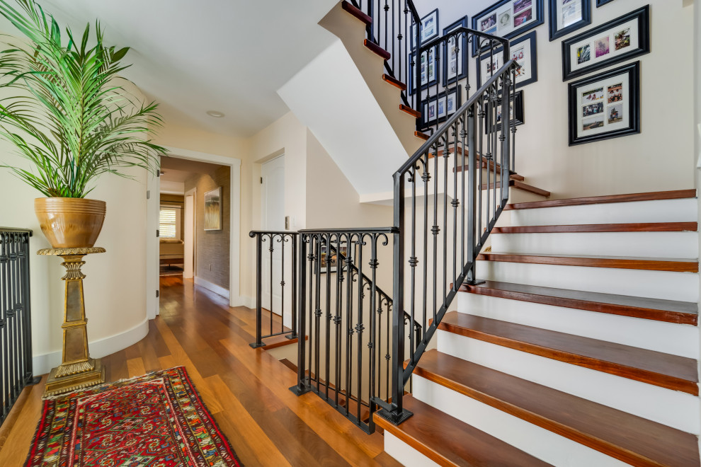 Ejemplo de escalera de estilo de casa de campo grande con escalones de madera, contrahuellas de madera pintada y barandilla de metal