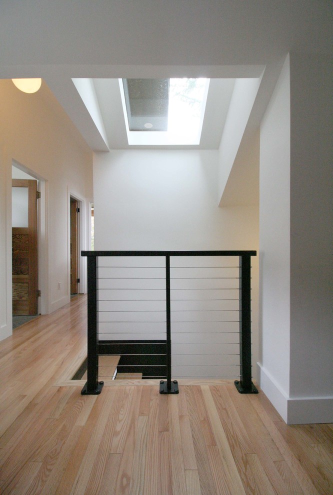 Imagen de escalera recta minimalista de tamaño medio con escalones de madera y contrahuellas de madera pintada